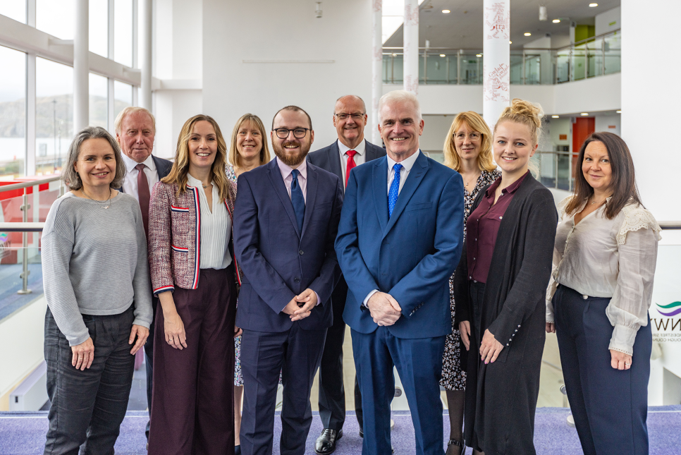 Culture Minister Jack Sargeant at Venue Cymru A group of people standing in the central atrium of Venue Cymru
